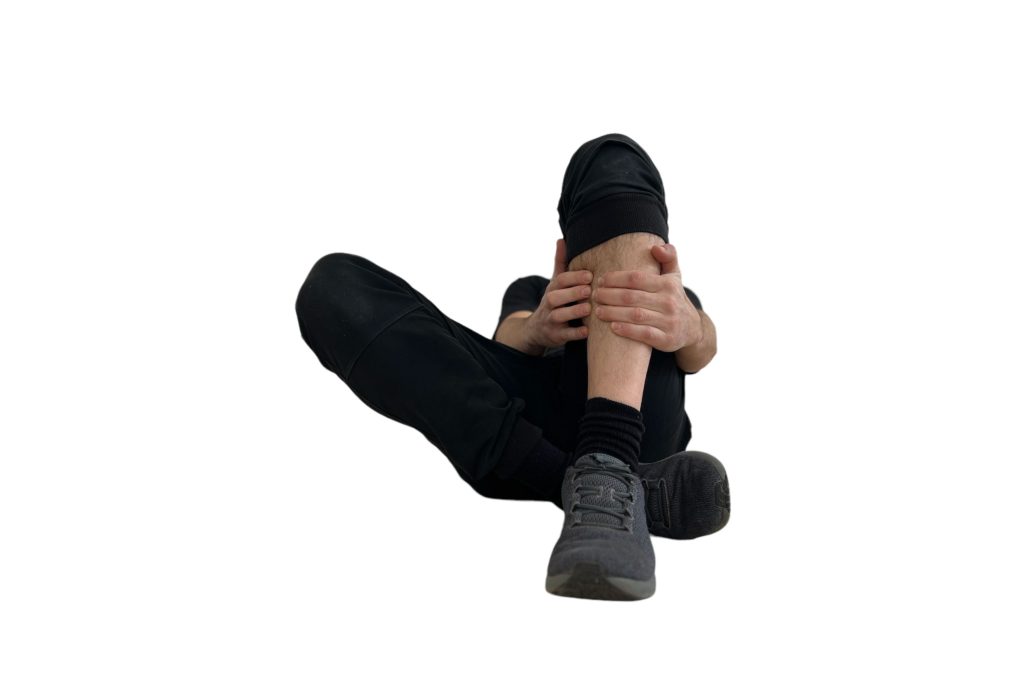 Hombre experimentando dolor de espinillas, conocido como periostitis tibial medial, mientras practica salto con cuerda