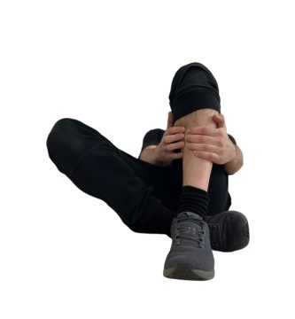 Hombre experimentando dolor de espinillas, conocido como periostitis tibial medial, mientras practica salto con cuerda