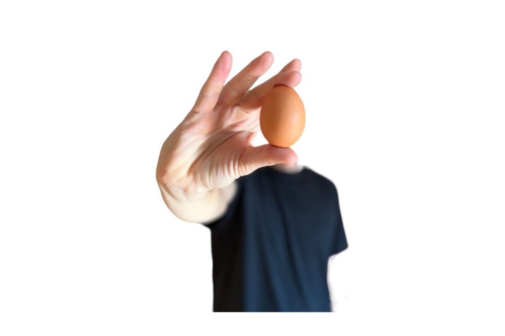 Huevo sostenido en la mano como símbolo de nutrición saludable para el ejercicio